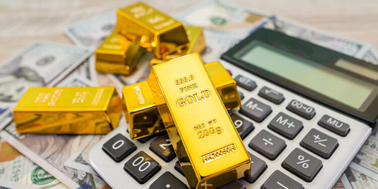 Gold bars on a calculator and scattered US dollar bills symbolize finance, investment, retirement security, and wealth management. | GoldZeus.com