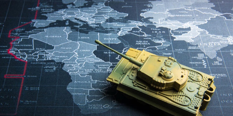 A model tank sits on a map focused on Europe, North Africa, and the Middle East, with various country names visible beneath the tank. | GoldZeus.com